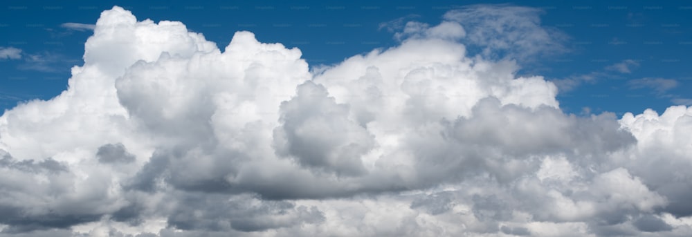 um avião voando através de um céu azul nublado