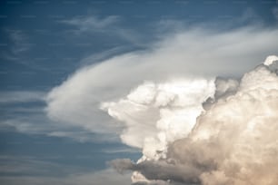 a large cloud is in the sky with a plane in the foreground