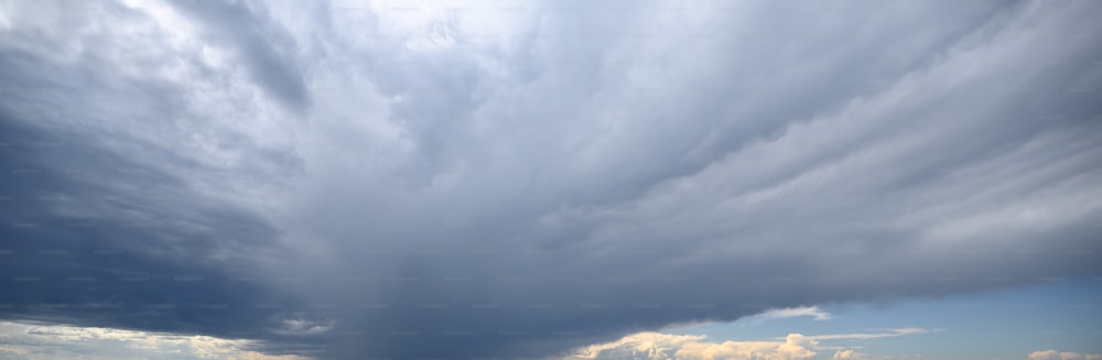 a large cloud is in the sky over a field