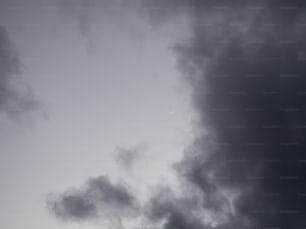 a plane flying through a cloudy sky on a cloudy day