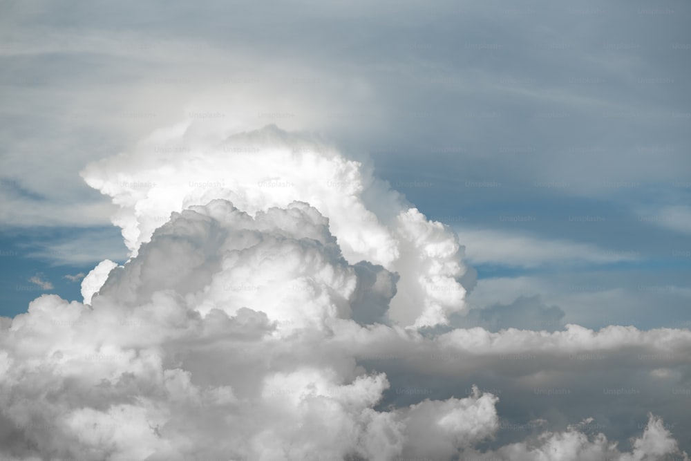 Una gran nube en el cielo con un avión en primer plano