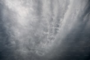 a plane flying through a cloudy sky on a cloudy day