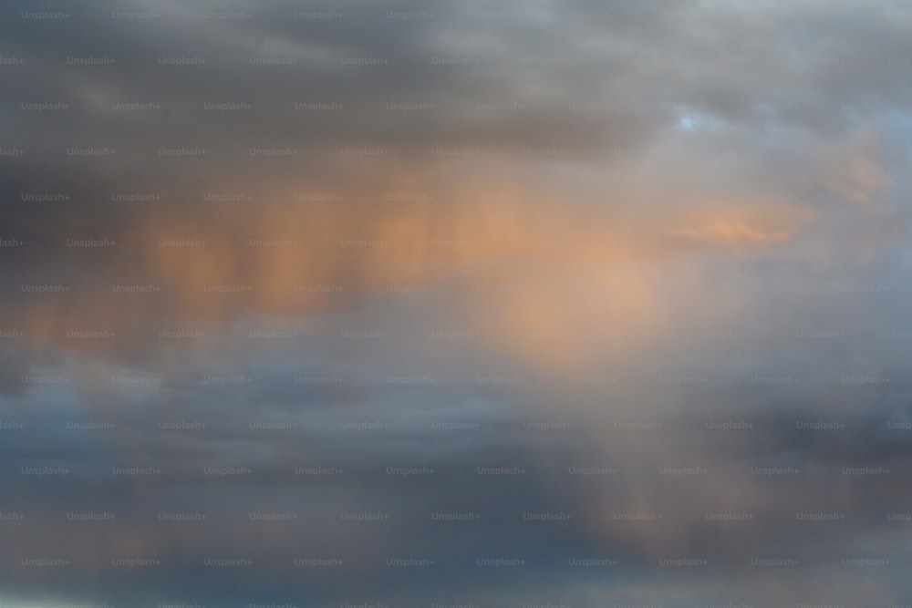 um avião voando através de um céu nublado em um dia ensolarado