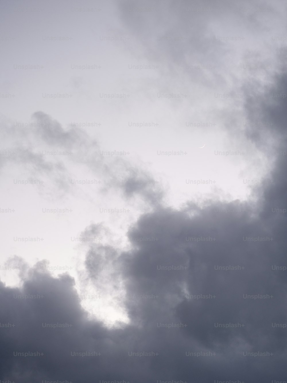 um avião voando através de um céu nublado em um dia nublado