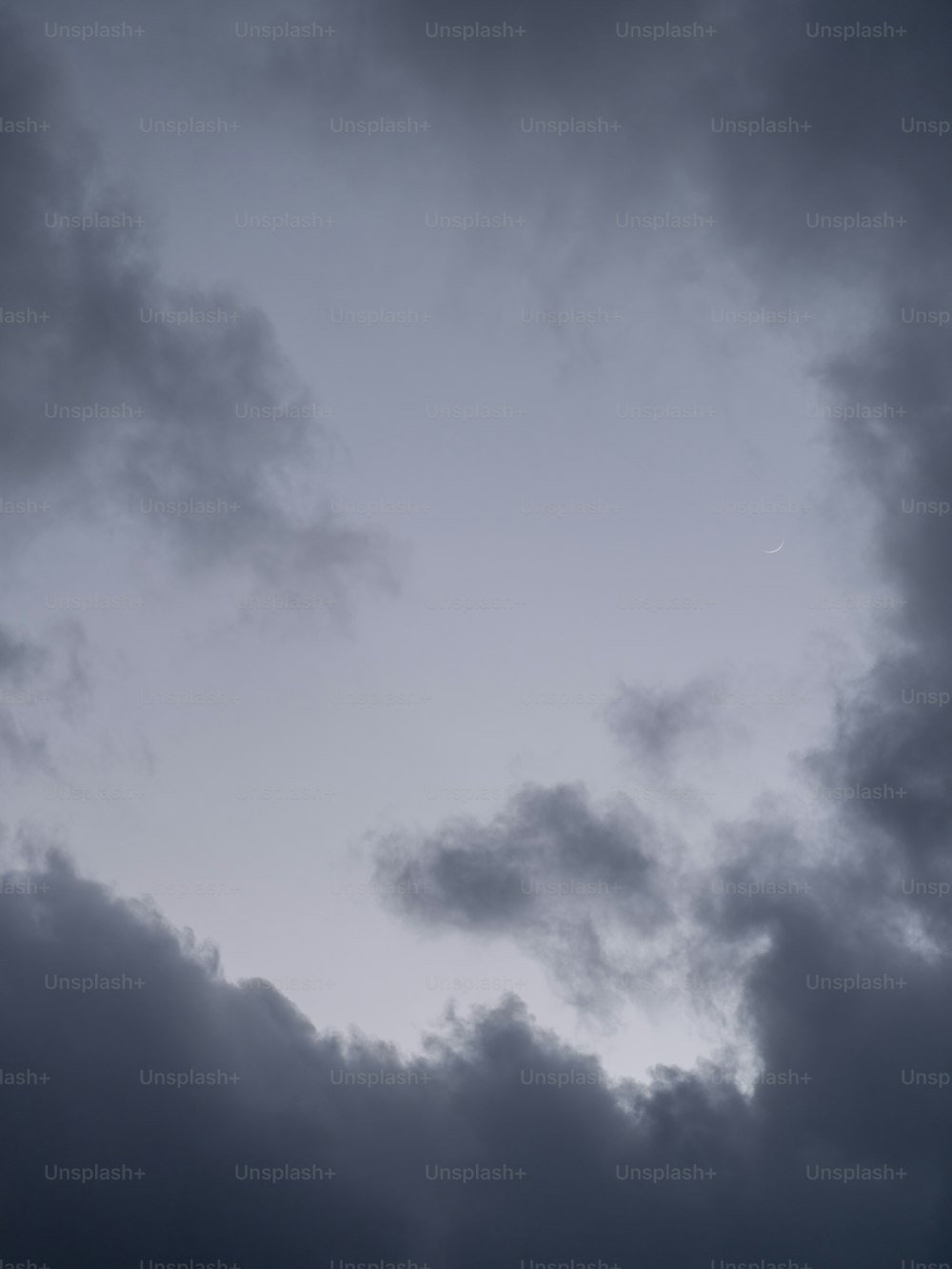 a plane flying through a cloudy sky on a cloudy day