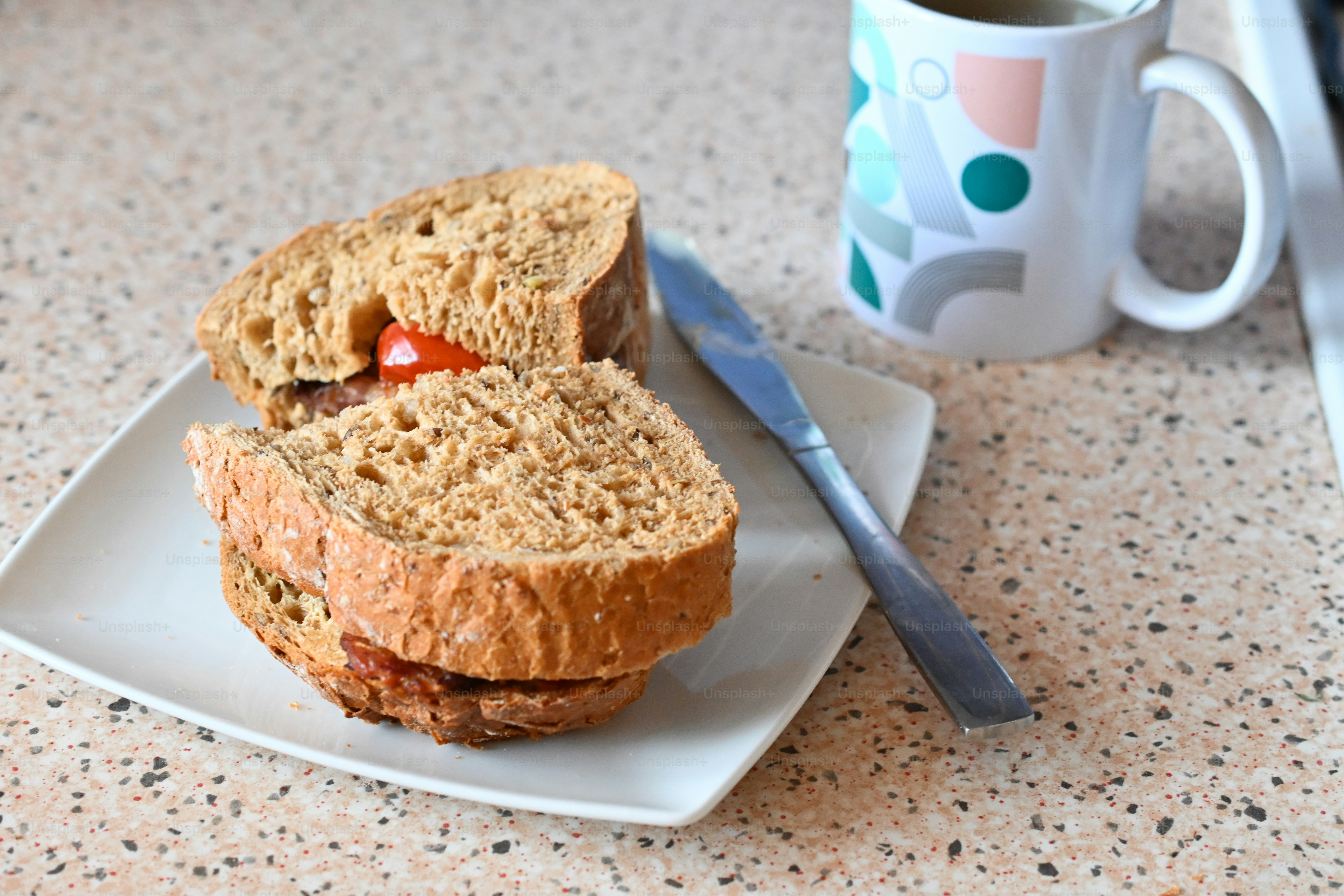 A close up of a sandwich on a plate near a cup of coffee photo ...