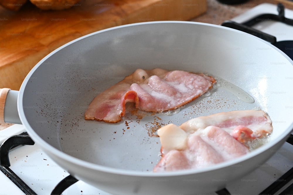 una sartén llena de tocino encima de una estufa