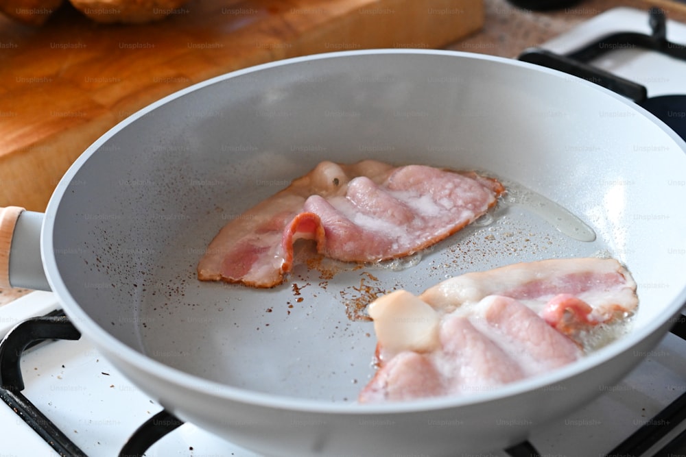 a frying pan filled with bacon on top of a stove