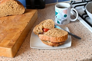 a close up of a sandwich on a plate near a cup of coffee