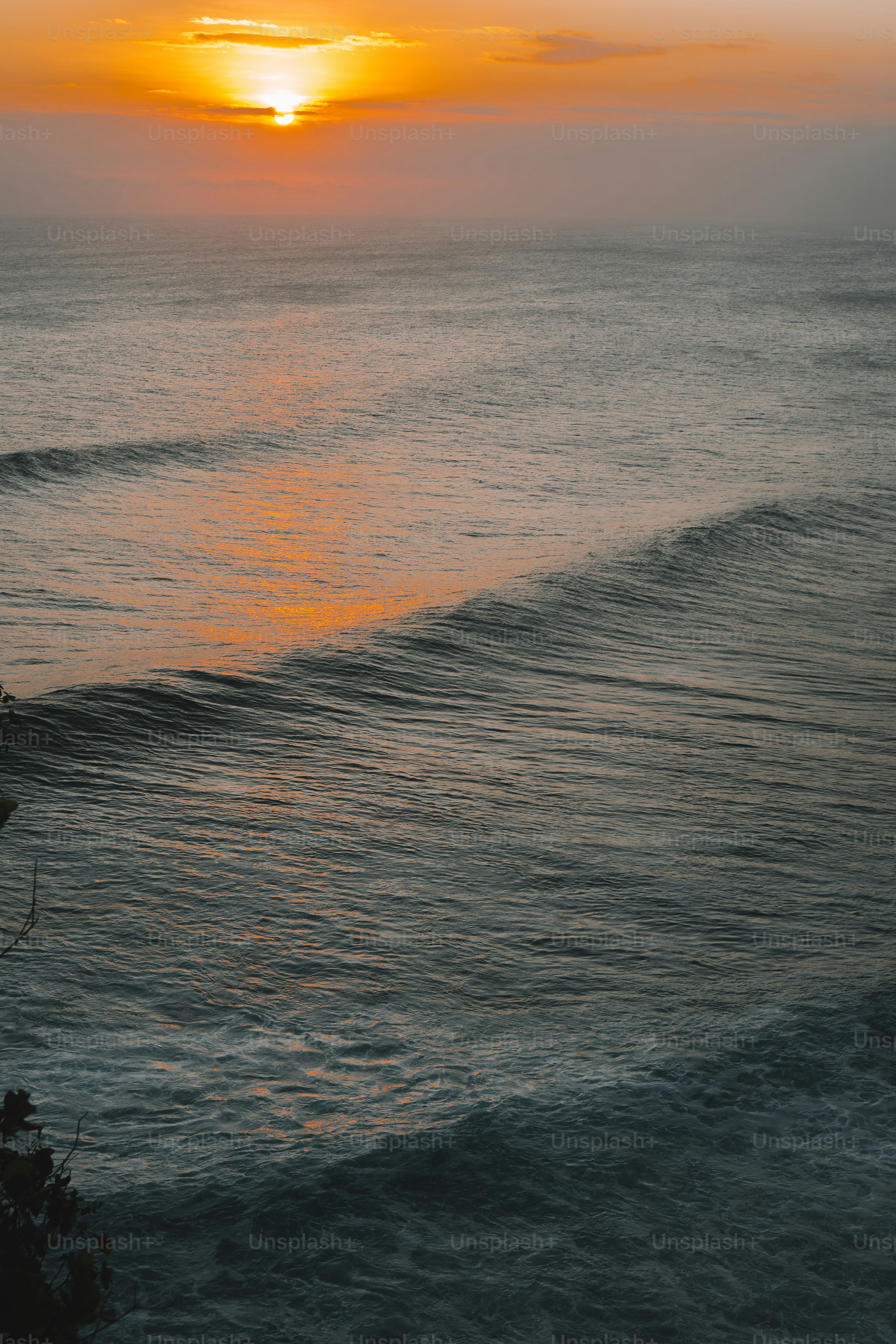 the sun is setting over the ocean with waves
