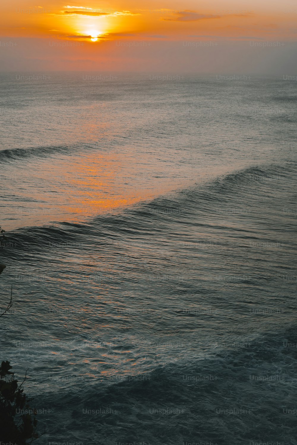 Die Sonne geht mit Wellen über dem Meer unter