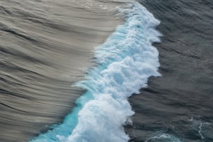 une personne sur une planche de surf au sommet d’une vague