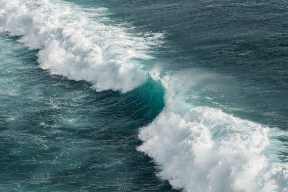 uma grande onda quebrando sobre o topo do oceano
