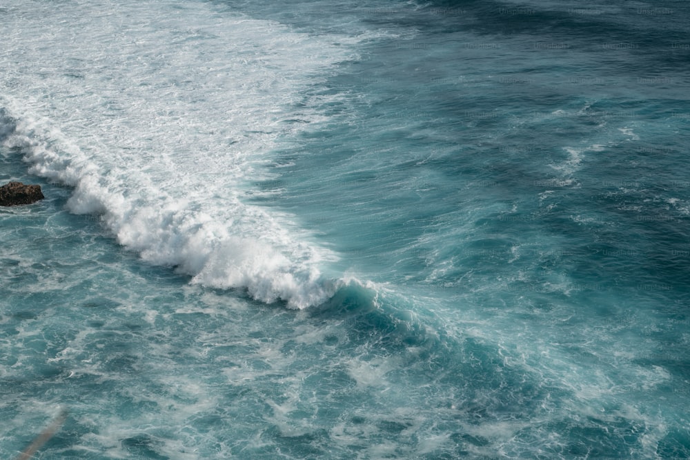 a wave crashes into the shore of the ocean