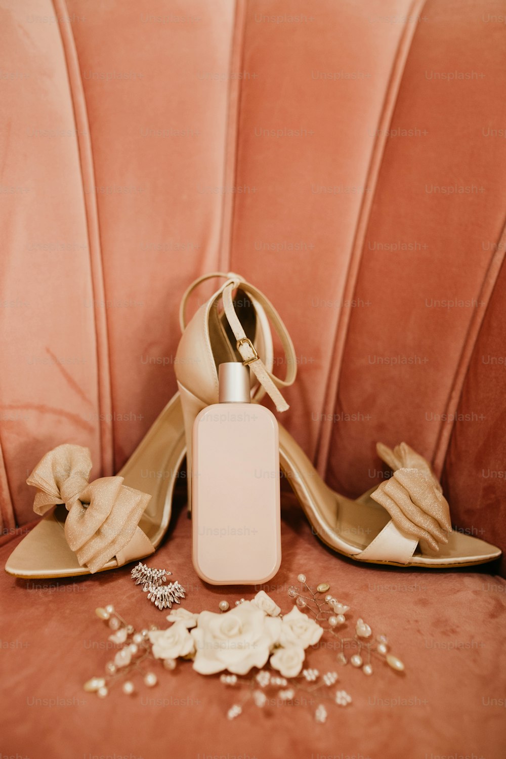 Un par de zapatos de tacón alto junto a una botella de perfume
