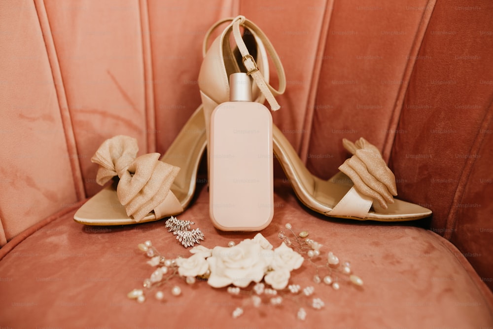 a pair of high heeled shoes next to a bottle of perfume