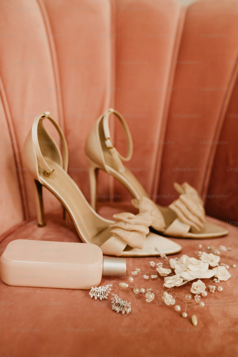 a pair of high heeled shoes sitting on top of a pink couch
