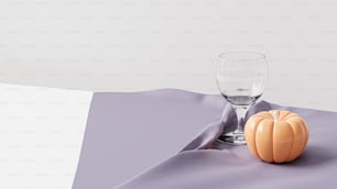 a glass of water and a pumpkin on a table