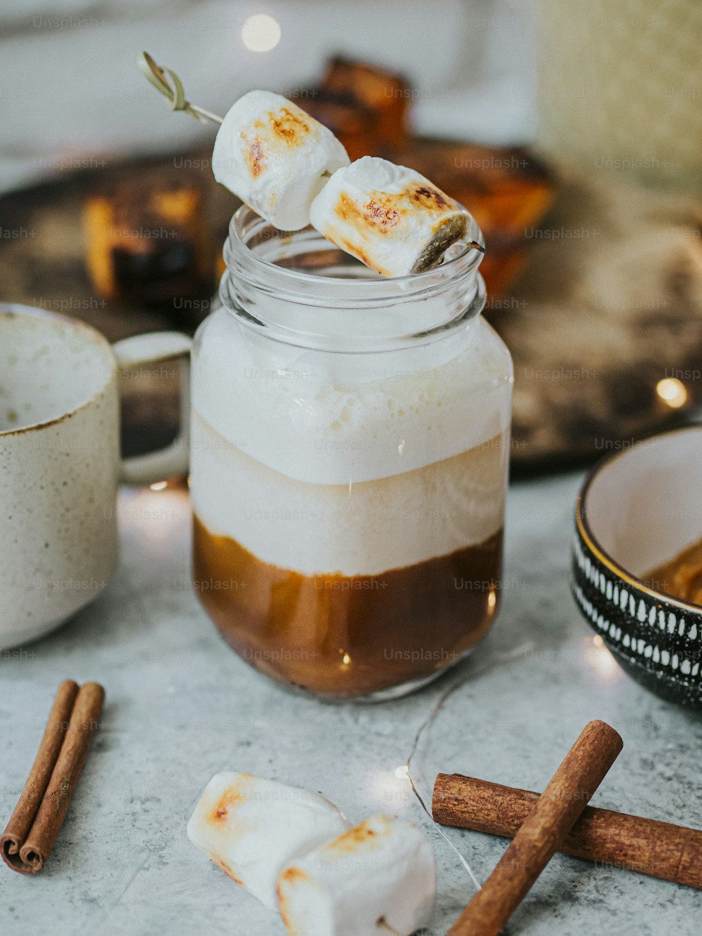 un frasco de chocolate caliente y malvaviscos sobre una mesa