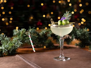 Una bebida en un vaso con un árbol de Navidad de fondo