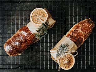 a loaf of bread with a slice of orange and a sprig of rosemary