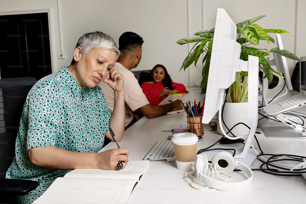 a woman sitting at a desk in front of a computer