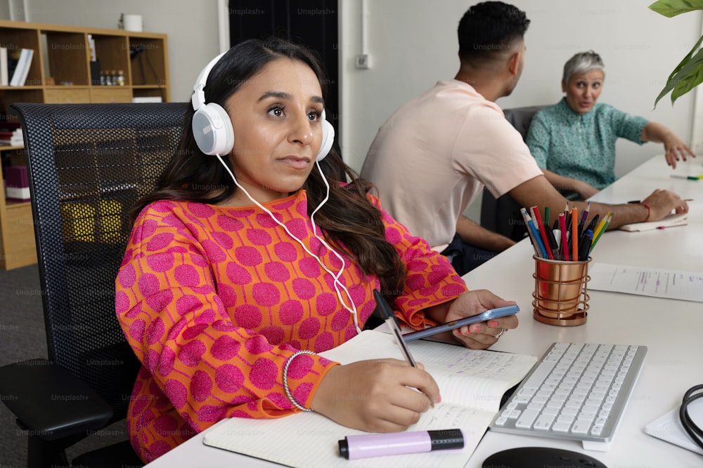 a woman sitting at a desk with headphones on