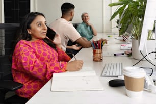 a woman sitting at a desk in front of a computer