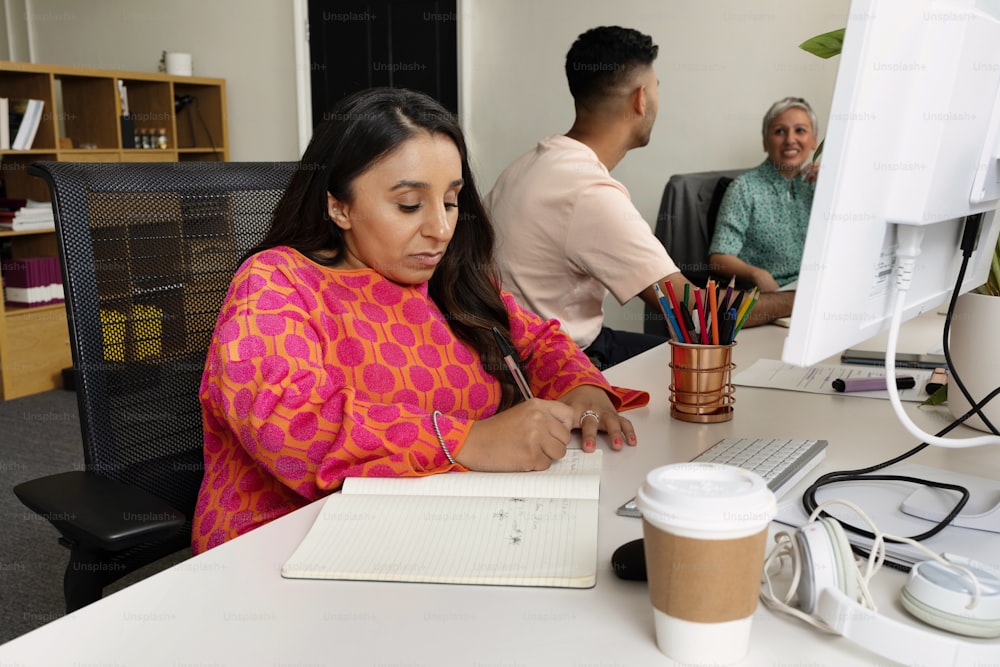 a woman sitting at a desk with a cup of coffee