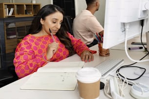 a woman sitting at a desk with a cup of coffee