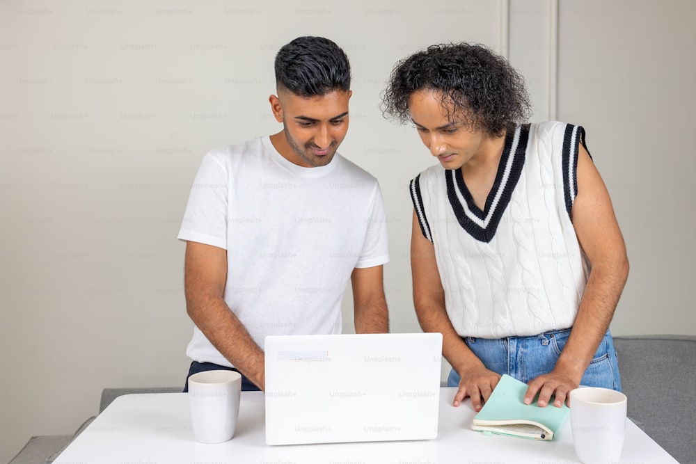 a man and a woman are looking at a laptop