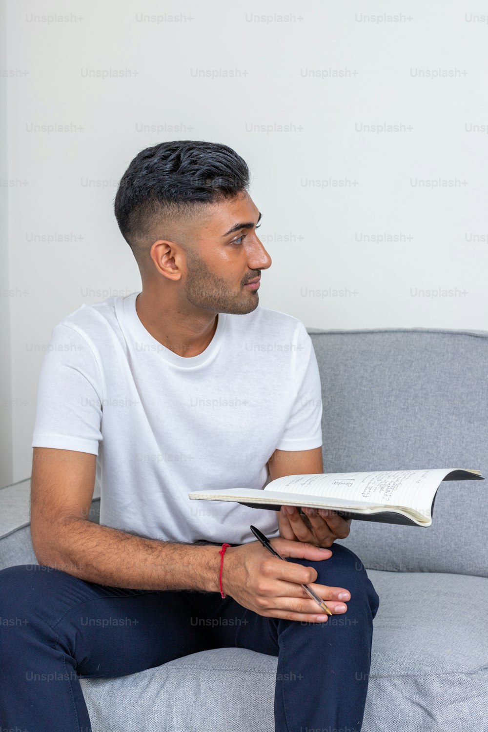 a man sitting on a couch reading a book