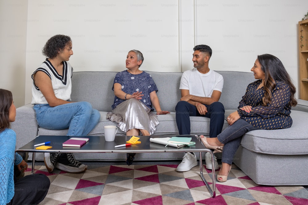 a group of people sitting on a couch talking
