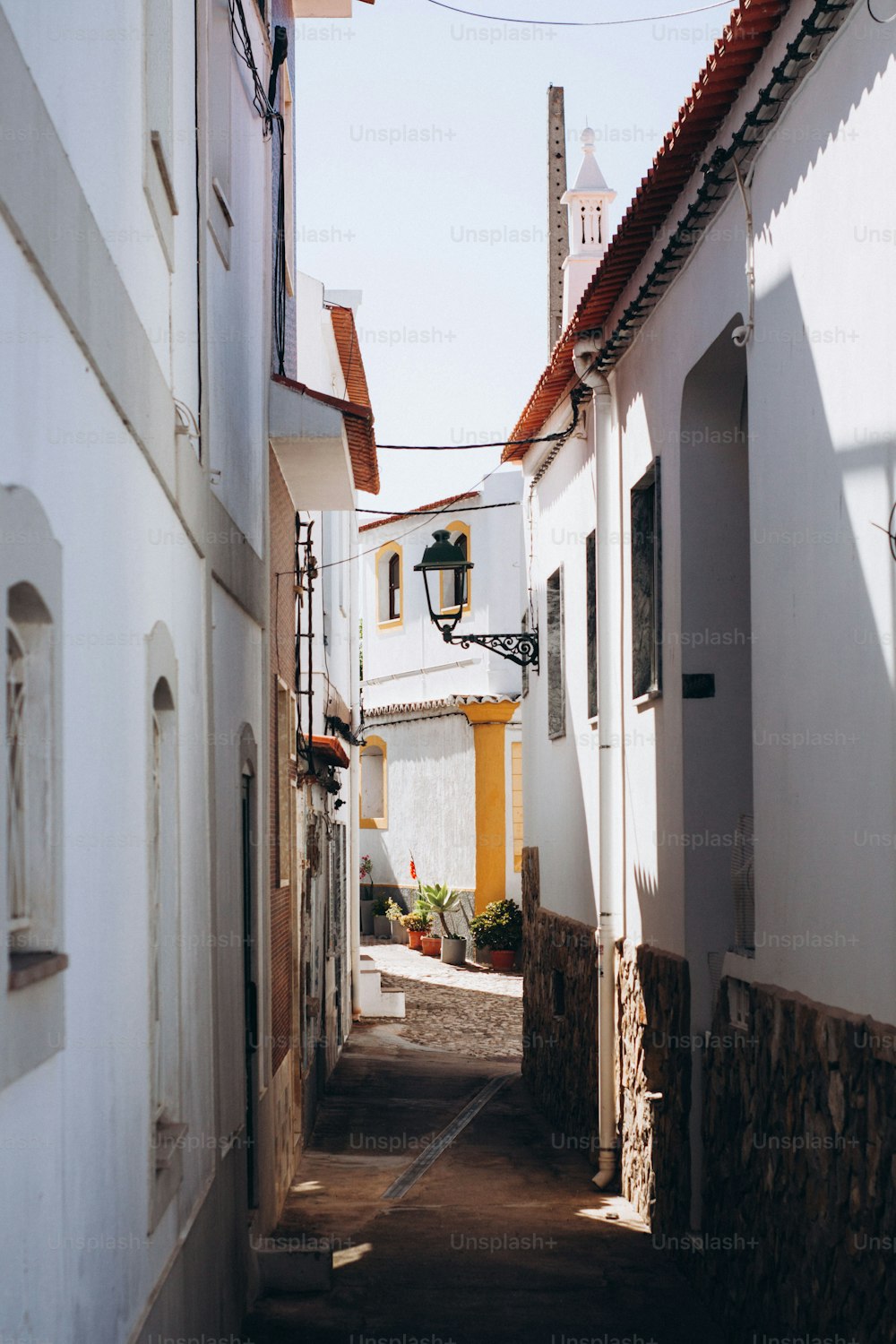 a narrow alley way with a clock tower in the distance