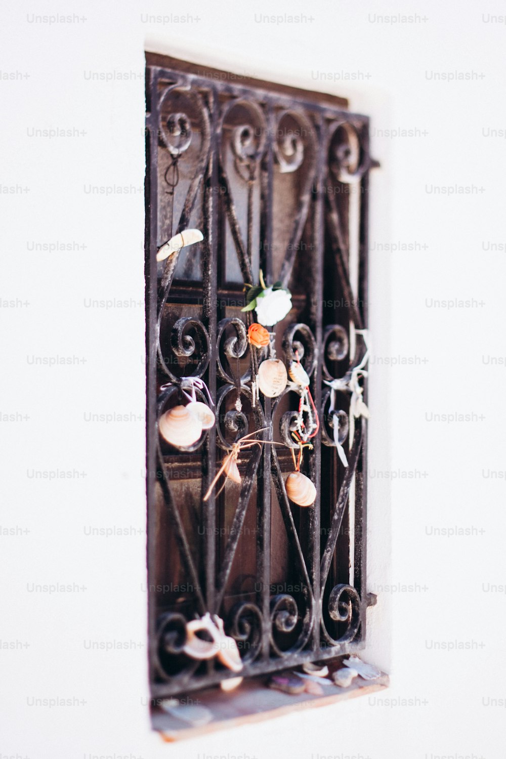 un cancello in ferro battuto con un mazzo di fiori su di esso