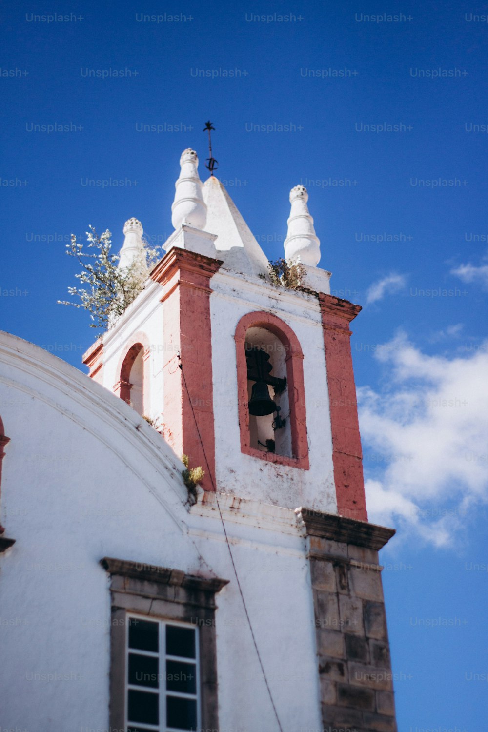 ein Kirchturm mit einem Glockenturm und einem Kreuz auf der Spitze