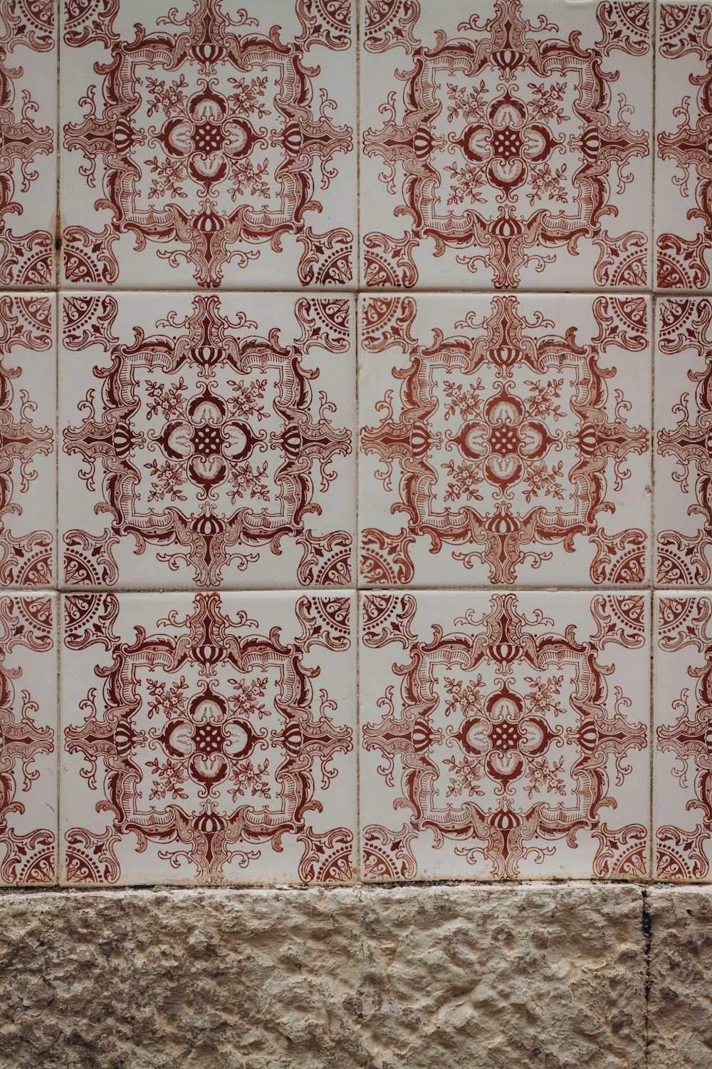 a red and white tiled wall with a clock on it
