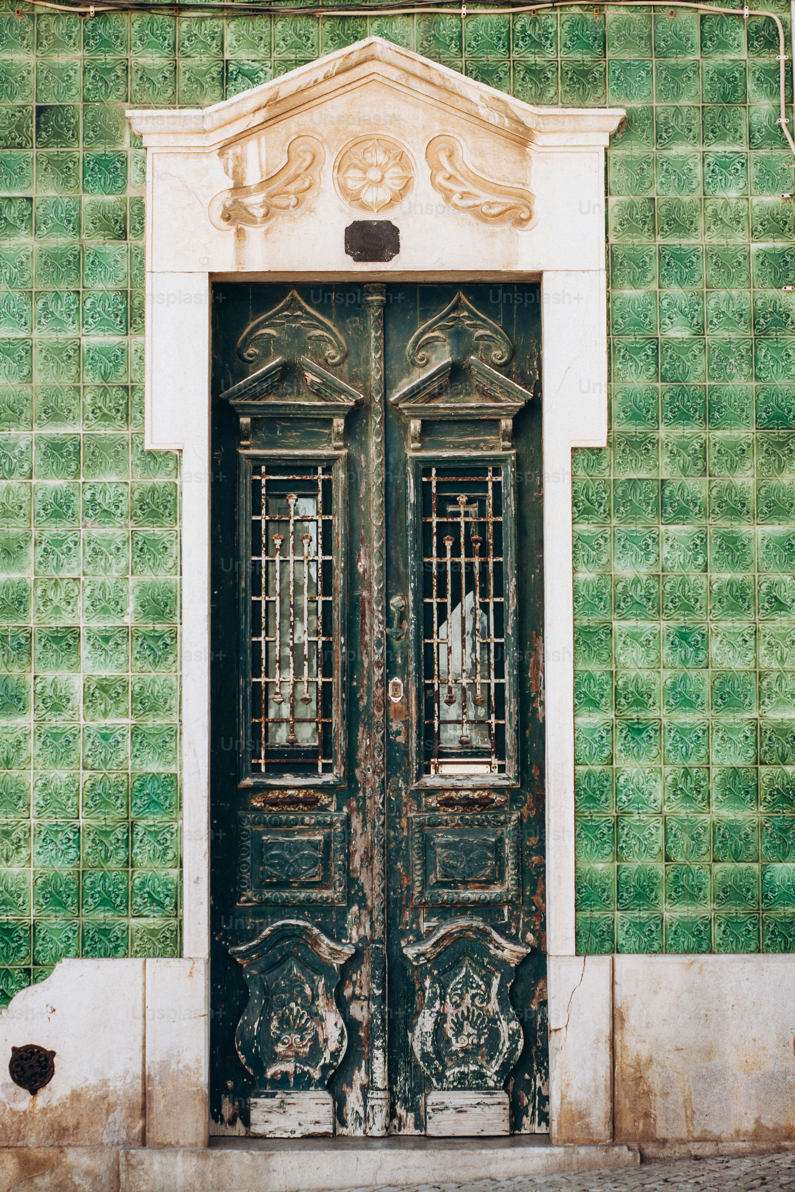 Un edificio verde y blanco con dos puertas