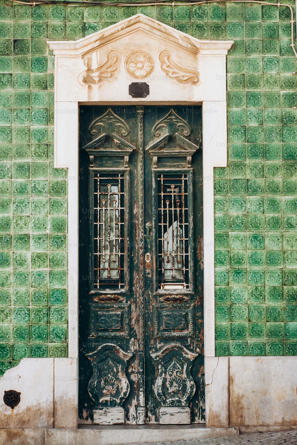 a green and white building with two doors