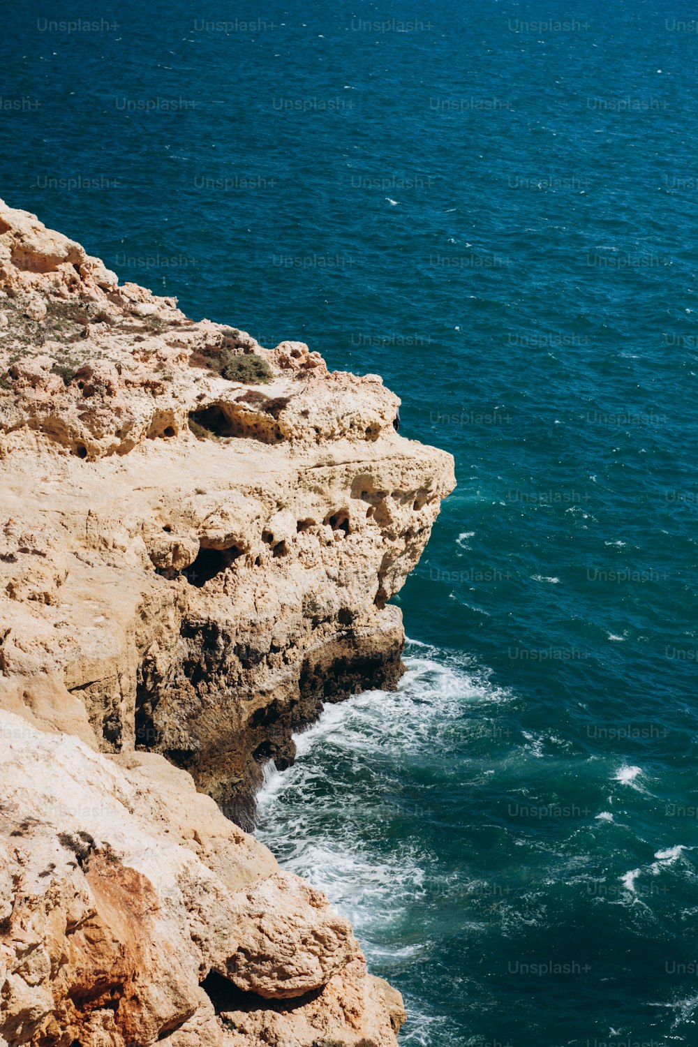 Una persona in piedi su una scogliera che si affaccia sull'oceano