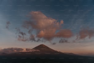 Una montagna con una nuvola nel cielo