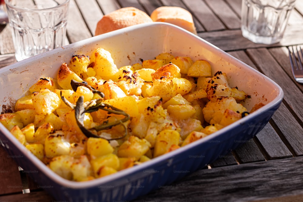 a casserole dish with potatoes and herbs in it