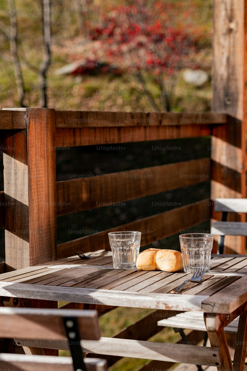une table en bois avec deux verres et du pain dessus
