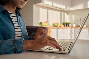 a woman sitting at a table using a laptop computer