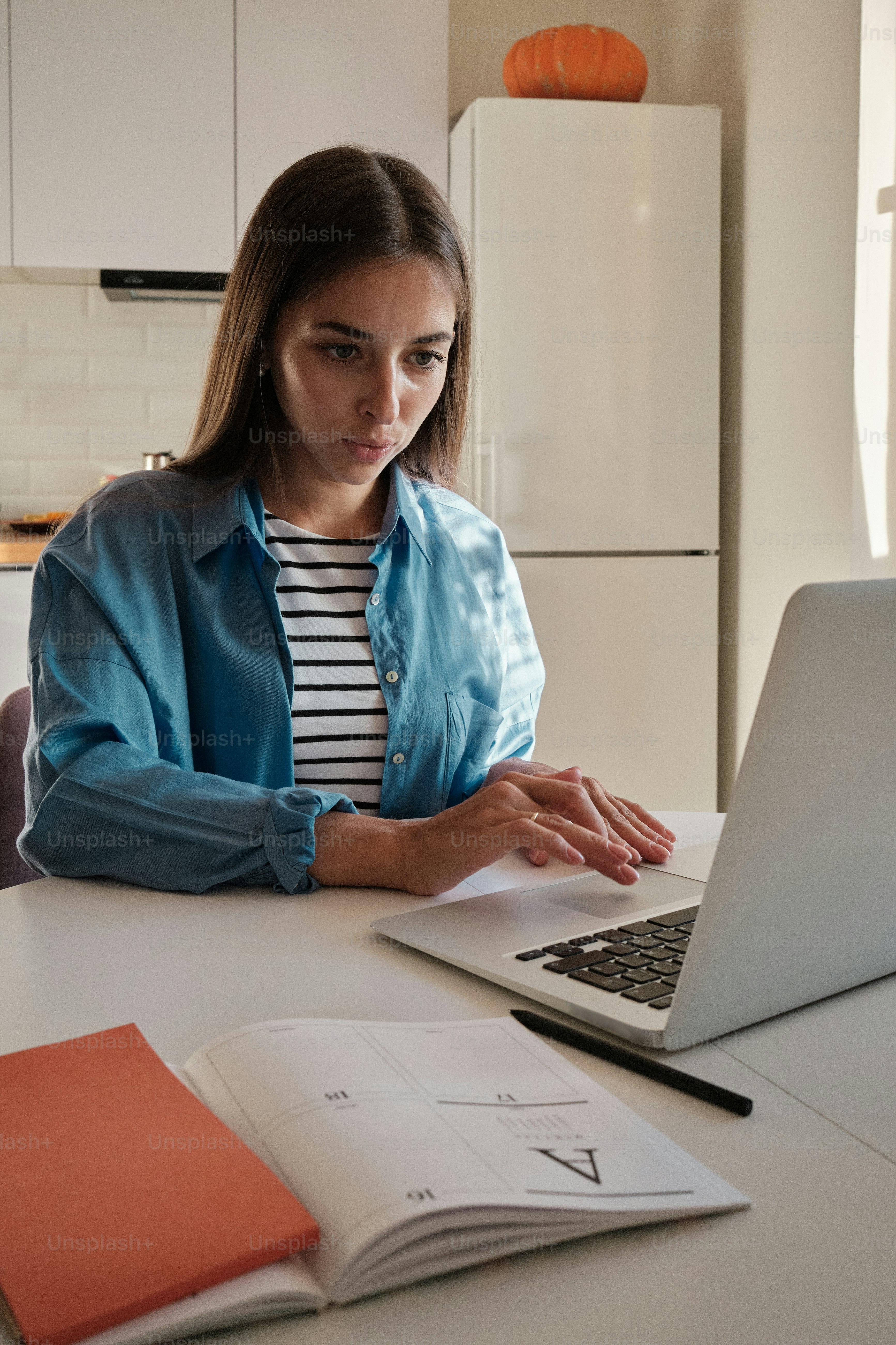 Una mujer sentada en una mesa usando una computadora portátil foto ...