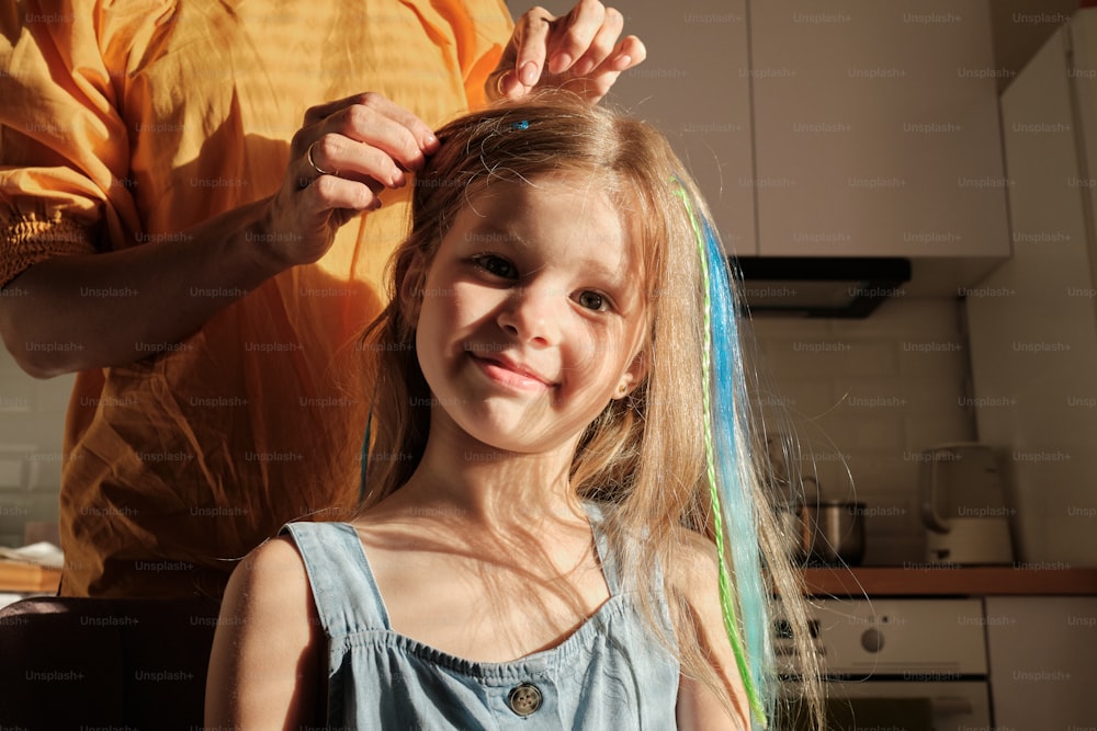 a little girl getting her hair colored by a man