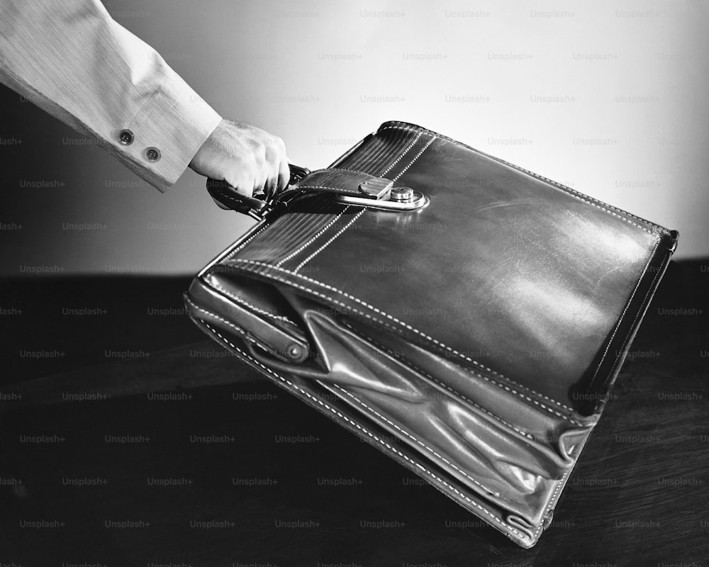 a person holding a briefcase on a table