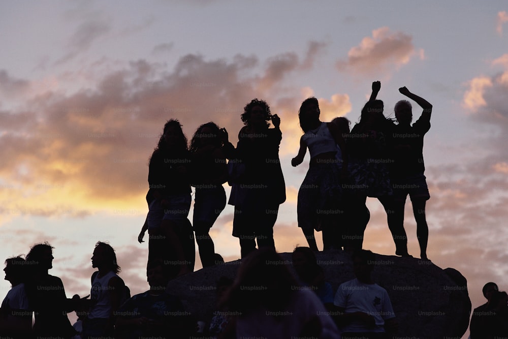 a group of people standing on top of a rock