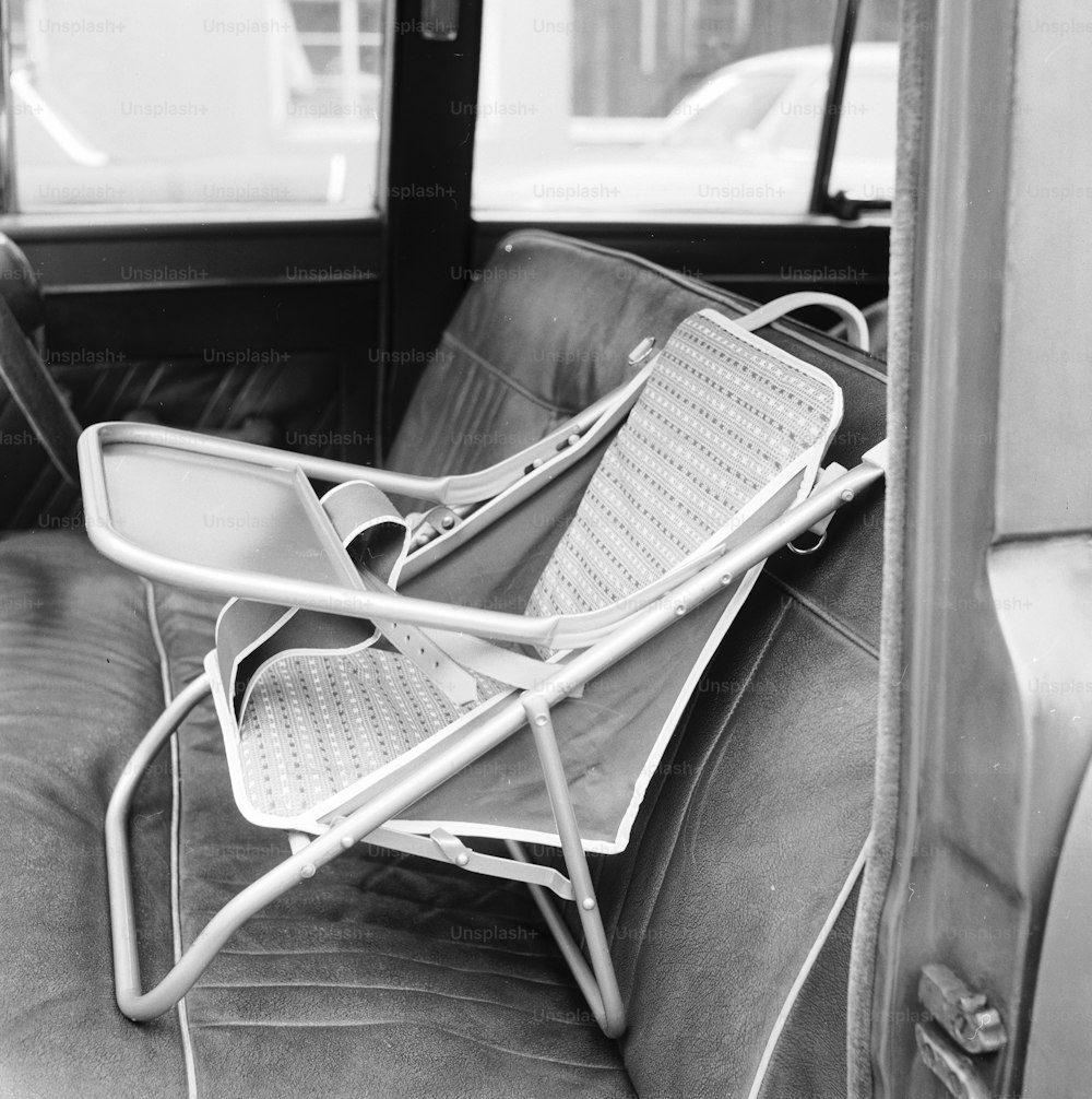 28 de febrero de 1961: Una silla de bebé plegable portátil fijada al asiento del pasajero sujeta al niño para un viaje más seguro.  (Foto de Chaloner Woods/Getty Images)