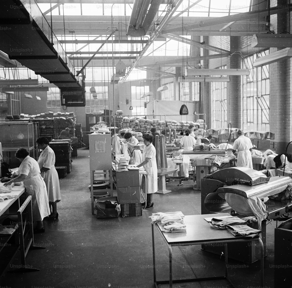 6 mars 1957 : Des femmes travaillent dans une blanchisserie très fréquentée.  (Photo de Chaloner Woods/Getty Images)
